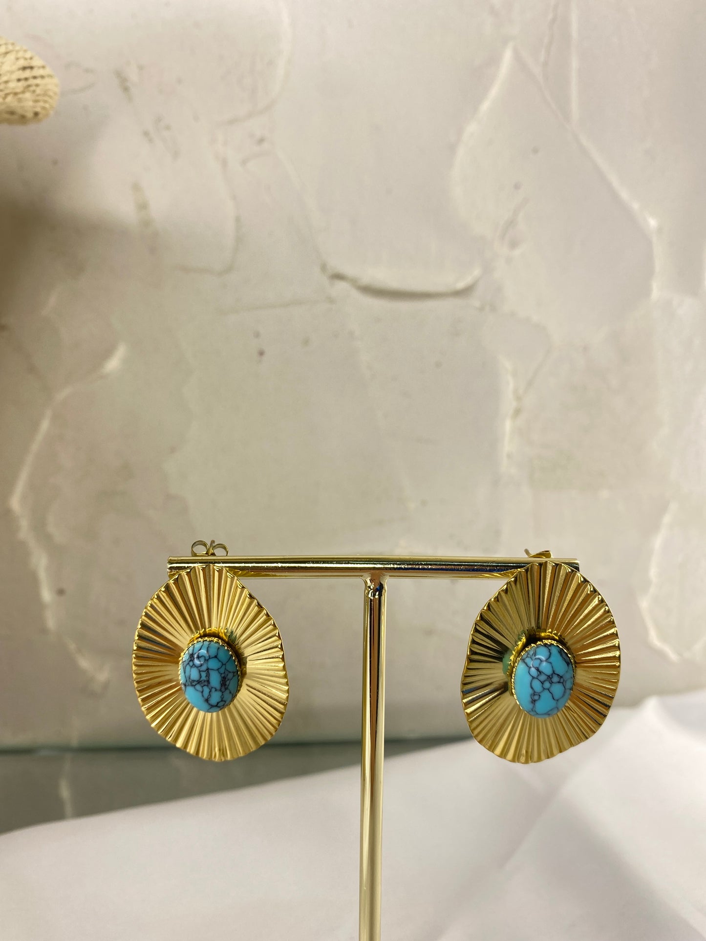 Gold earring with brick details and blue stone