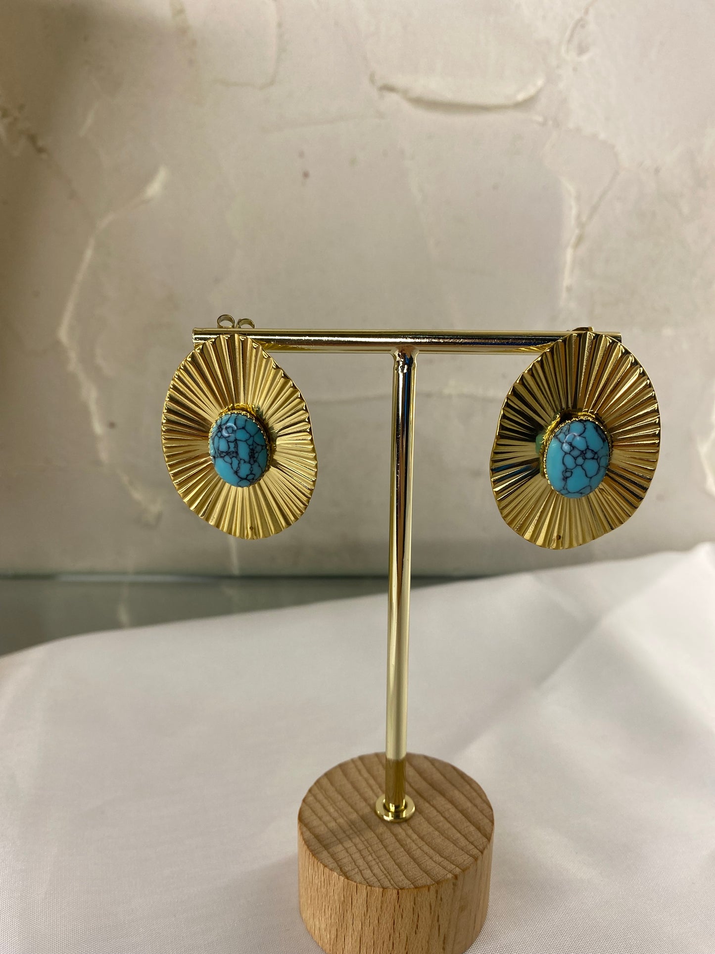 Gold earring with brick details and blue stone